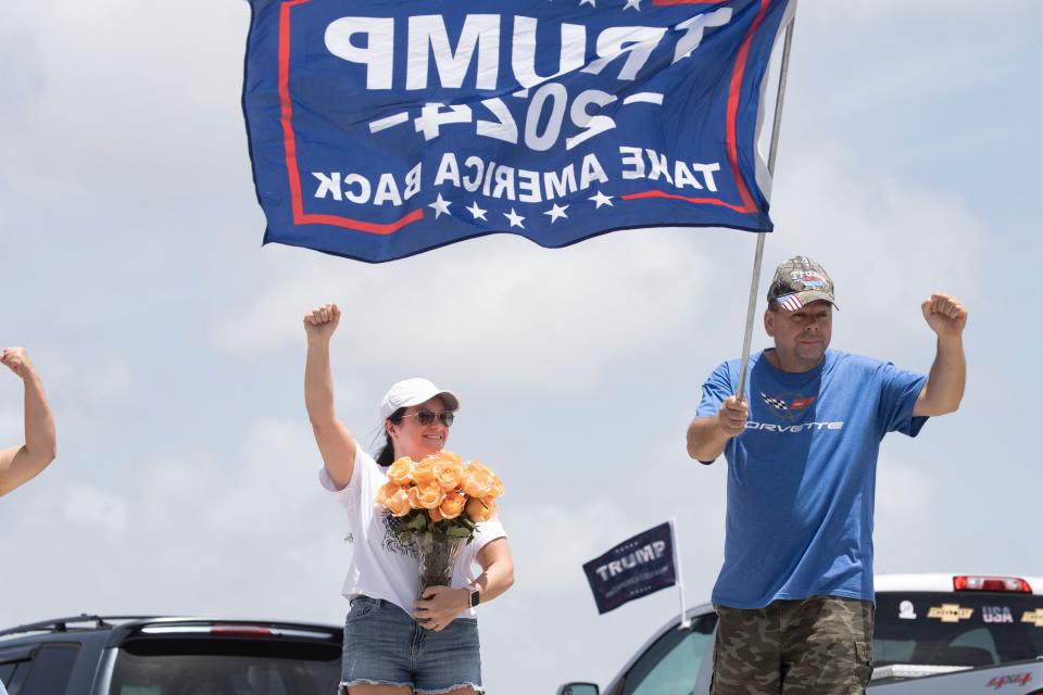 Angela Rotella, left, holds a bouquet of flowers for former President Donald Trump near his Mar-a-Lago home on Sunday.