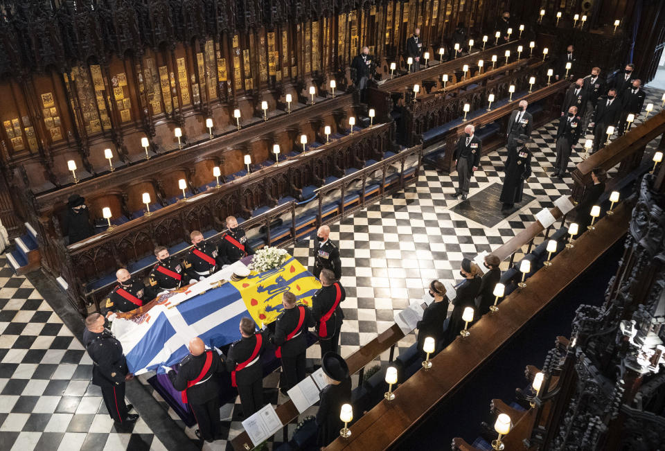 Queen Elizabeth watches as pallbearers carry the coffin of the Duke of Edinburgh during his funeral, at St George's Chapel in Windsor Castle, Windsor, England, Saturday April 17, 2021. Prince Philip died April 9 at the age of 99 after 73 years of marriage to Britain's Queen Elizabeth II. (Dominic Lipinski/Pool via AP)