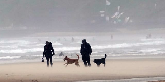Walkers on a windy Tynemouth beach