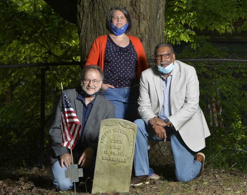 From left, Chris Magoc, Mercyhurst University history professor, Melinda Meyer, chair of Preservation Erie, and historian Johnny Johnson gather at the grave of Robert McConnell in the Gospel Hill Burial Ground in this 2020 photo. The McConnell buried there is the great-grandson of the enslaved Robert McConnell.