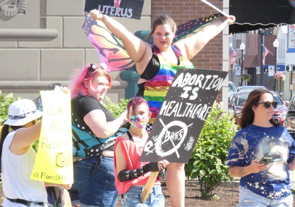 Wearing butterfly wings, Shelby Currey of Bucyrus is surrounded by other protesters during a "We Won't Go Back" rally in Washington Park in downtown Bucyrus on Monday.