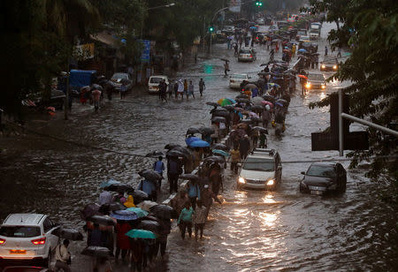 Commuters walk through water-logged roads after rains in Mumbai, India, August 29, 2017. REUTERS/Shailesh Andrade