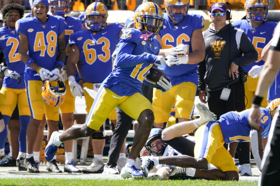 Pittsburgh's M.J. Devonshire (12) returns a punt for a touchdown during the first half of an NCAA college football game against Rhode Island, Saturday, Sept. 24, 2022, in Pittsburgh. (AP Photo/Keith Srakocic)