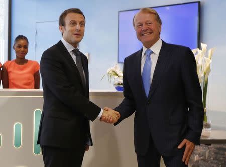 French Economy Minister Emmanuel Macron (L) shakes hands with Cisco Executive Chairman John Chambers during a visit at the Cisco France headquarters in Issy-Les-Moulineaux, near Paris, France, October 8, 2015. REUTERS/Jacky Naegelen