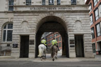 Police horses walk through an archway entrance to St Bartholomew's Hospital in London, where Britain's Prince Philip is being treated, Tuesday, March 2, 2021. Buckingham Palace said Philip, the 99-year-old husband of Queen Elizabeth II, was transferred from King Edward VII's Hospital to St Bartholomew's Hospital yesterday to undergo testing and observation for a pre-existing heart condition as he continues treatment for an unspecified infection. (AP Photo/Matt Dunham)