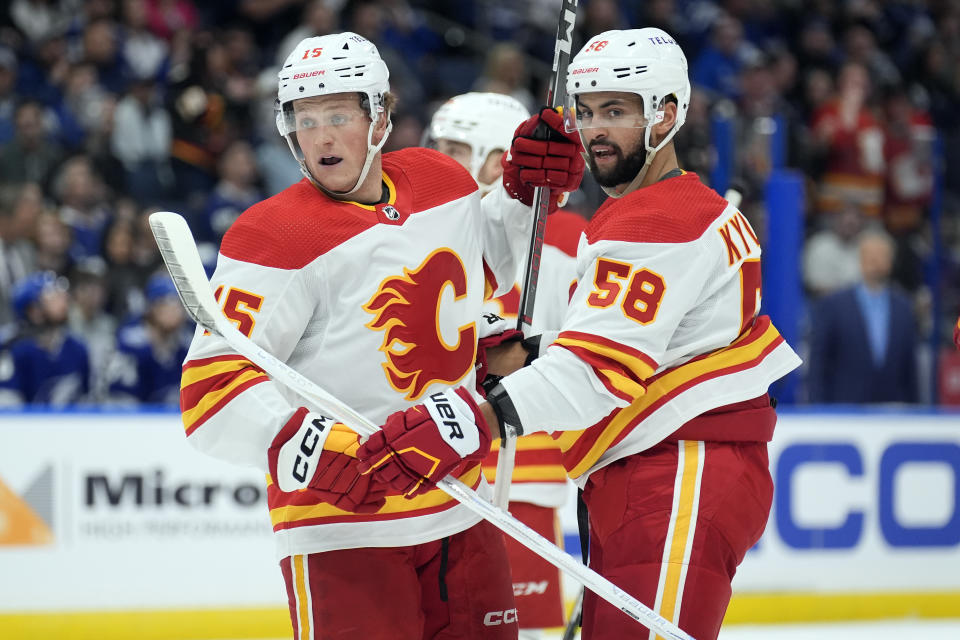 Calgary Flames left wing Dryden Hunt (15) celebrates his goal against the Tampa Bay Lightning with center Oliver Kylington (58) during the first period of an NHL hockey game Thursday, March 7, 2024, in Tampa, Fla. (AP Photo/Chris O'Meara)