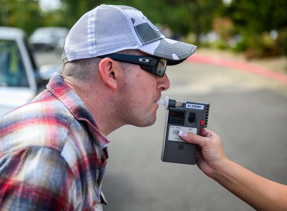 CHP officer Mike Maher blows into a breathalyzer during a DUI investigation simulation during a media boot camp at the CHP academy in West Sacramento, Wednesday, Sept. 18, 2019.