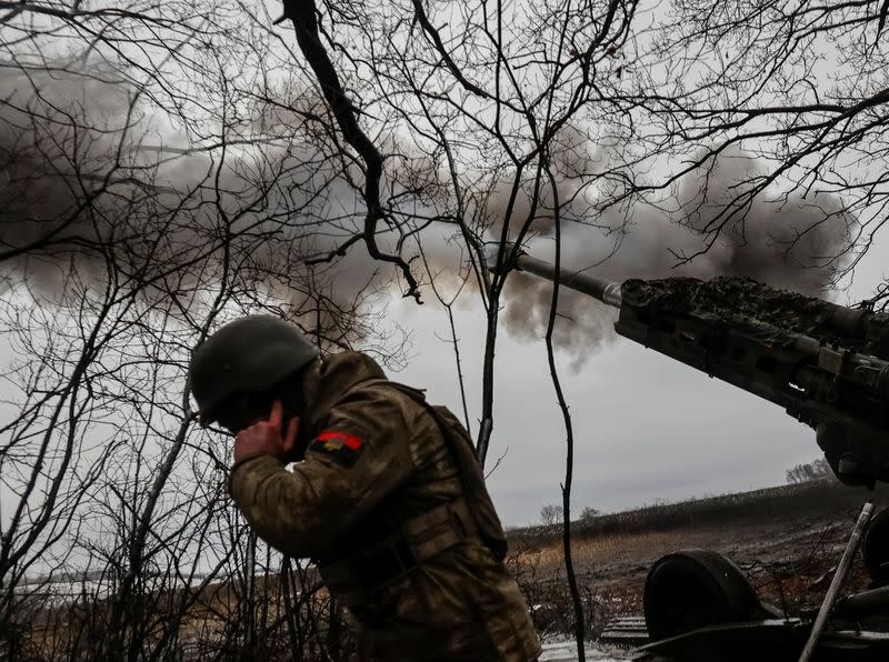 Un miembro del servicio ucraniano se tapa los oídos mientras se dispara un proyectil desde un obús M777 en una línea del frente, en medio del ataque de Rusia a Ucrania, en la región de Donetsk, Ucrania