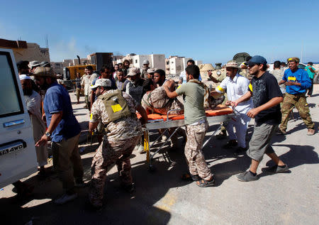 A wounded fighter of Libyan forces allied with the U.N.-backed government is evacuated on a stretcher by his comrades at the eastern frontline of fighting with Islamic State militants, in Sirte, Libya, October 20, 2016. REUTERS/Ismail Zitouny