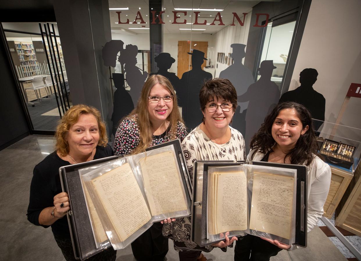 From left, LuAnn Mims, Rebecca Whalon and Kelly Koos hold the restored ledgers of Lakeland's founding documents and its city council meetings from 1885 to 1890 in the Lakeland History and Culture Center at the Lakeland Public Library. The pages, more than 100 years old, were crumbling. But the library and city hired an outside company to restore them last year.