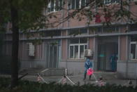 Hospital staff wash the emergency entrance of Wuhan Medical Treatment Center, where some infected with a new virus are being treated, in Wuhan, China, Wednesday, Jan. 22, 2020. The number of cases of a new coronavirus from Wuhan has risen to over 400 in China health authorities said Wednesday. (AP Photo/Dake Kang)