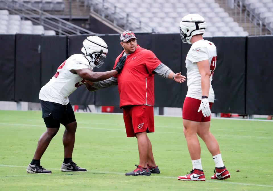 Arizona Cardinals outside linebackers coach Rob Rodriguez works with linebackers Victor Dimukeje (52) and Cameron Thomas (97) during training camp at State Farm Stadium in Glendale on July 28, 2023.