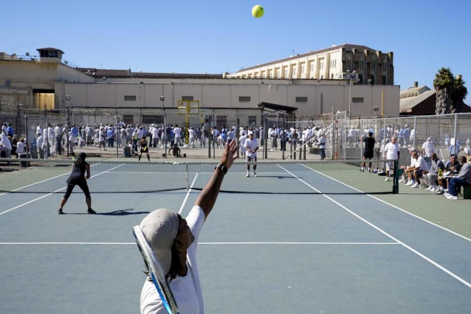 James Duff, bottom, serves during a tennis match between fellow San Quentin State Prison inmates and visiting players in San Quentin, Calif., Saturday, Aug. 13, 2022. (AP Photo/Godofredo A. Vásquez)