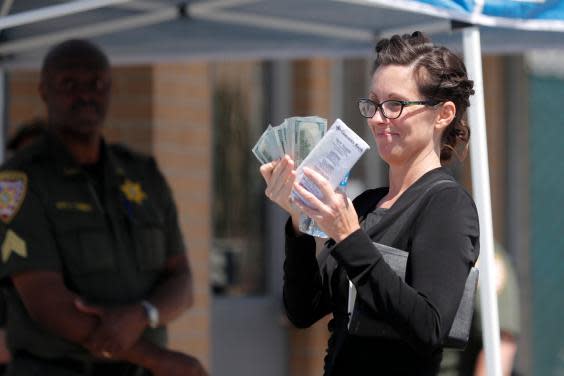 Shaye Spell, wife of Lousiana pastor Tony Spell, flashes wads of cash as she arrives at the East Baton Rouge parish jail to post bond for him following his arrest for flouting coronavirus lockdown orders (AP)