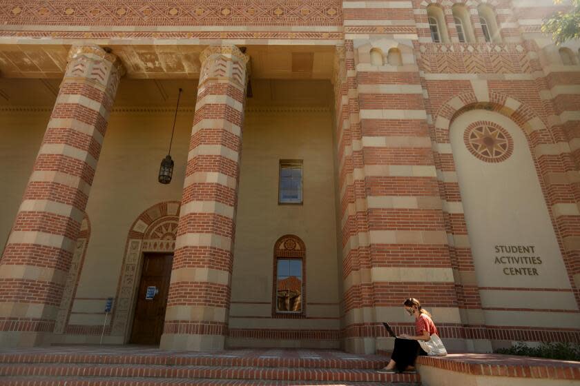 LOS ANGELES, CA - AUGUST 05, 2020 - - Professor Adina Matisoff, who teaches Global Studies at UCLA, works on the steps in front of the Student Activities Center on a nearly empty UCLA campus in Los Angeles on August 13, 2020. Professor Matisoff was working outside because she was not allowed to work in her office indoors. The empty campus is a preview of what the Fall semester will look like during the coronavirus pandemic. Most classes, much like the summer classes, will be held online at the university. (Genaro Molina / Los Angeles Times)