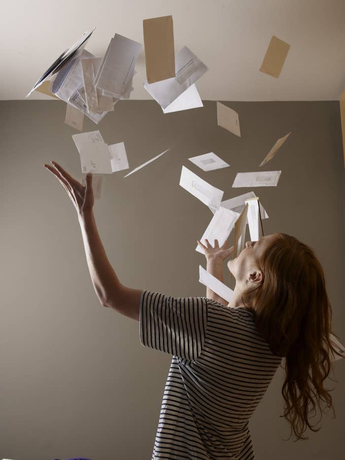 Young woman throwing bills in the air