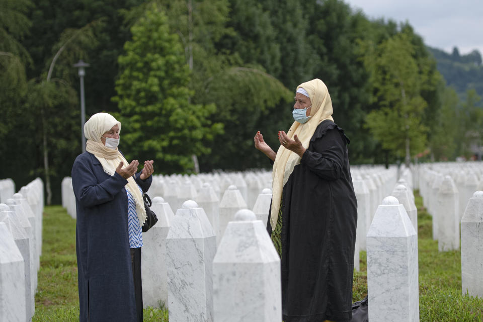 Women, wearing masks for protection against the COVID-19 infection, pray at the memorial cemetery in Potocari, near Srebrenica, Bosnia, Tuesday, July 7, 2020. A quarter of a century after they were killed in Sreberenica, eight Bosnian men and boys will be laid to rest Saturday, July 11. Over 8,000 Bosnian Muslims perished in 10 days of slaughter after the town was overrun by Bosnian Serb forces in the closing months of the country’s 1992-95 fratricidal war. (AP Photo/Kemal Softic)