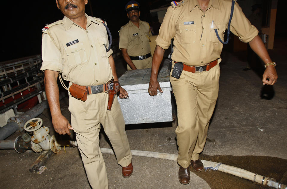 Indian police officials carry a sealed box containing materials seized for an ongoing investigation from the Italian cargo vessel, the Enrica Lexie anchored at the Cochin Oil Terminal, at the port in Kochi, India, early Sunday, Feb. 26, 2012. Italy's foreign minister will visit India to seek the release of two Italian marines accused of fatally shooting two Indian fishermen off southwest India. The marines were part of the cargo ship's security team, and India says they mistook the fishermen for pirates and killed them last week. (AP Photo/Aijaz Rahi)