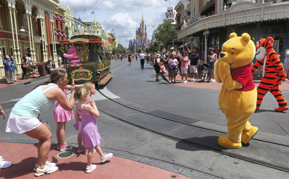 Young guests enjoy seeing Winnie The Pooh, and Tigger too, at the Magic Kingdom at Walt Disney World, in Lake Buena Vista, Fla., Monday, May 17, 2021, after Disney Co. eased face mask requirements over the weekend. Guests are allowed to go maskless in outdoor areas of the parks. Indoor attractions, shops and Disney transportation at the resort all still require masks. (Joe Burbank/Orlando Sentinel via AP)