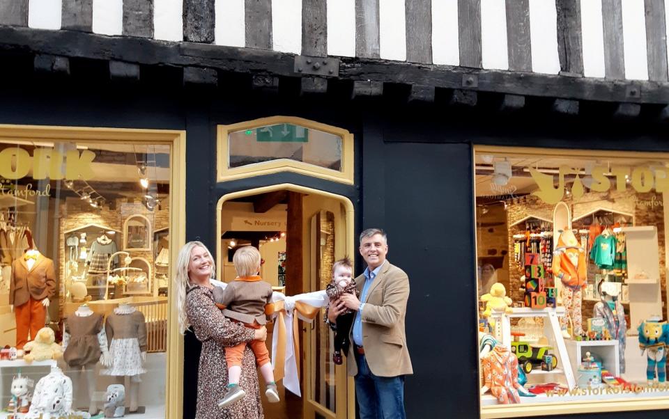 Marianne Rawlins with her family at the opening of her shop, the frontage of which is painted black and a colour named cherished gold