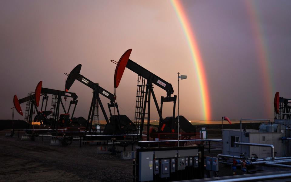 A rainbow appears behind an oil and gas field in Alberta, Canada