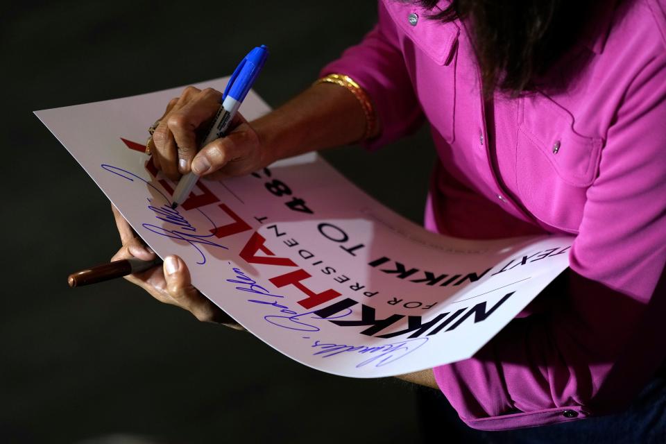 Republican presidential candidate Nikki Haley signs a poster during a town hall campaign event, Wednesday, May 17, 2023, in Ankeny, Iowa. (AP Photo/Charlie Neibergall)