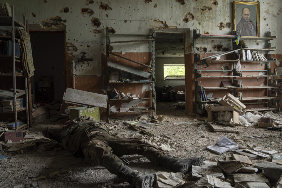 The body of a Russian soldier lies inside a building in the recently retaken village of Blahodatne, Ukraine, Saturday, June 17, 2023. (AP Photo/Evgeniy Maloletka)