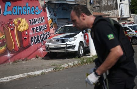 A federal police expert is seen near a site where an armed gang holds people hostage after they robbed a securities company at the Viracopos airpoart freight terminal, in Campinas