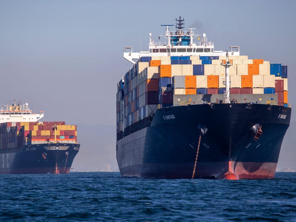 Two container ships floating on ocean carrying hundreds of shipping containers