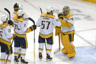 Nashville Predators goaltender Juuse Saros (74) is congratulated by teammates after defeating the New York Rangers 1-0 in an NHL hockey game, Sunday, Dec. 12, 2021, in New York. The Nashville Predators won 1-0. (AP Photo/Noah K. Murray)