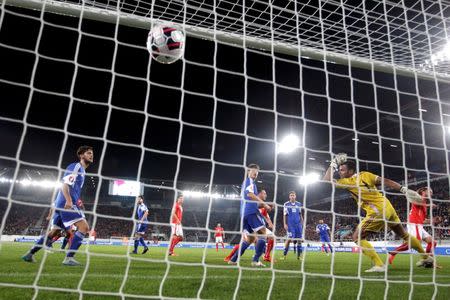 Switzerland's Michael Lang (R) scores a goal against San Marino's goalkeeper Aldo Simoncini during their Euro 2016 Group E qualifying soccer match in St. Gallen, Switzerland October 9, 2015. REUTERS/Arnd Wiegmann