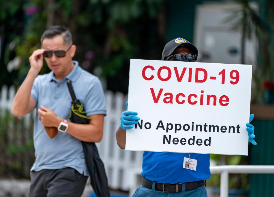 A health care worker directs people to a COVID-19 vaccination site in West Palm Beach, Fla., on May 14.
