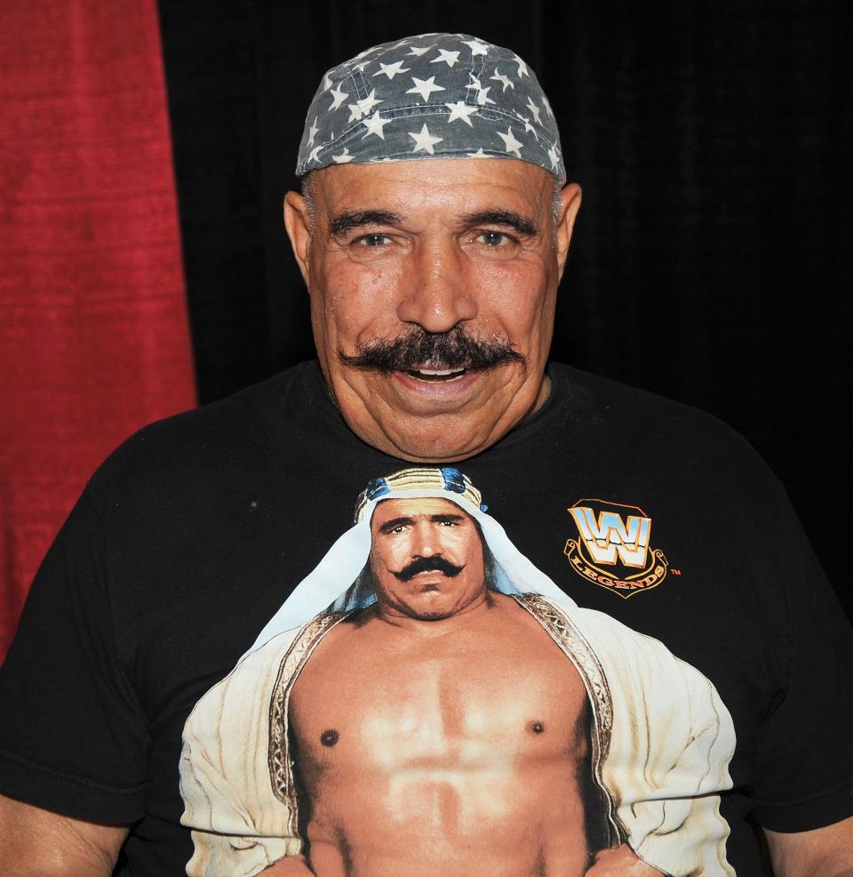 The Iron Sheik wearing a headband and a t-shirt with himself on it