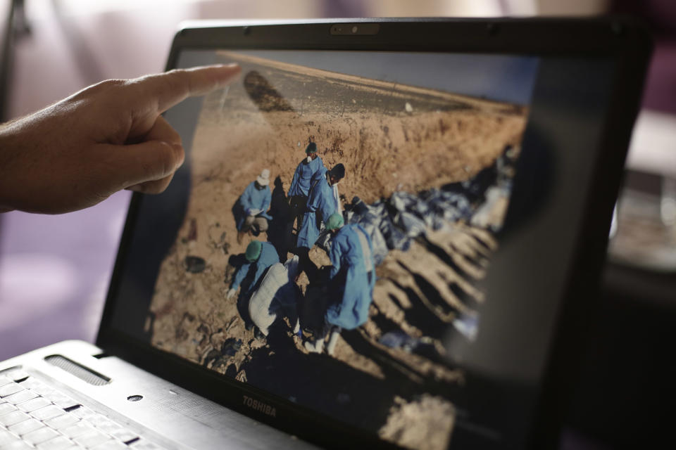 FILE - In this May 17, 2016, file, photo, Sirwan Jalal, Director of Mass Graves for the Kurdish Regional Government, points to an image of the site of a mass grave during an interview with the Associated Press in Irbil, northern Iraq. U.N. investigators said Tuesday, Nov. 6, 2018 that they have verified the location of more than 200 mass grave sites from the time of the Islamic State group’s reign in northern Iraq, containing the bodies of between 6,000 and 12,000 victims. (AP Photo/Maya Alleruzzo, File)