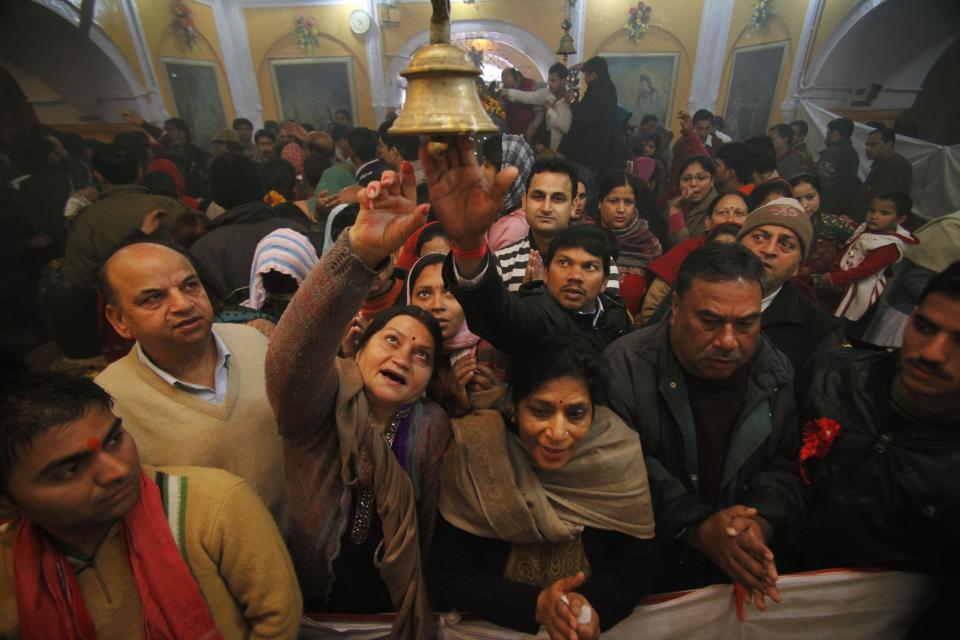 Indian Hindu devotees try to ring a bell tied to a chain as they perform rituals at a temple during Mahashivratri festival celebrations in Jammu, India, Monday, Feb. 20, 2012. Hindus across the world are celebrating Mahashivratri, or Shiva's night festival. (AP Photo/Channi Anand)