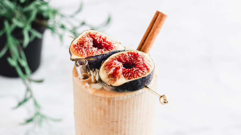 Close up on smoothie with fresh figs and cinnamon stick
