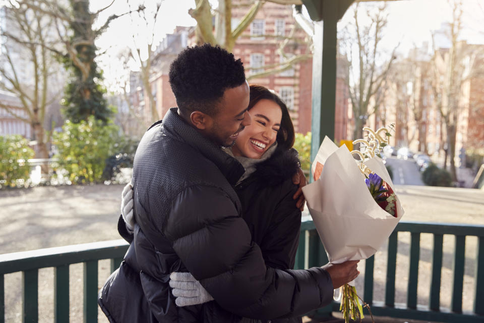 A couple hugging on a front porch