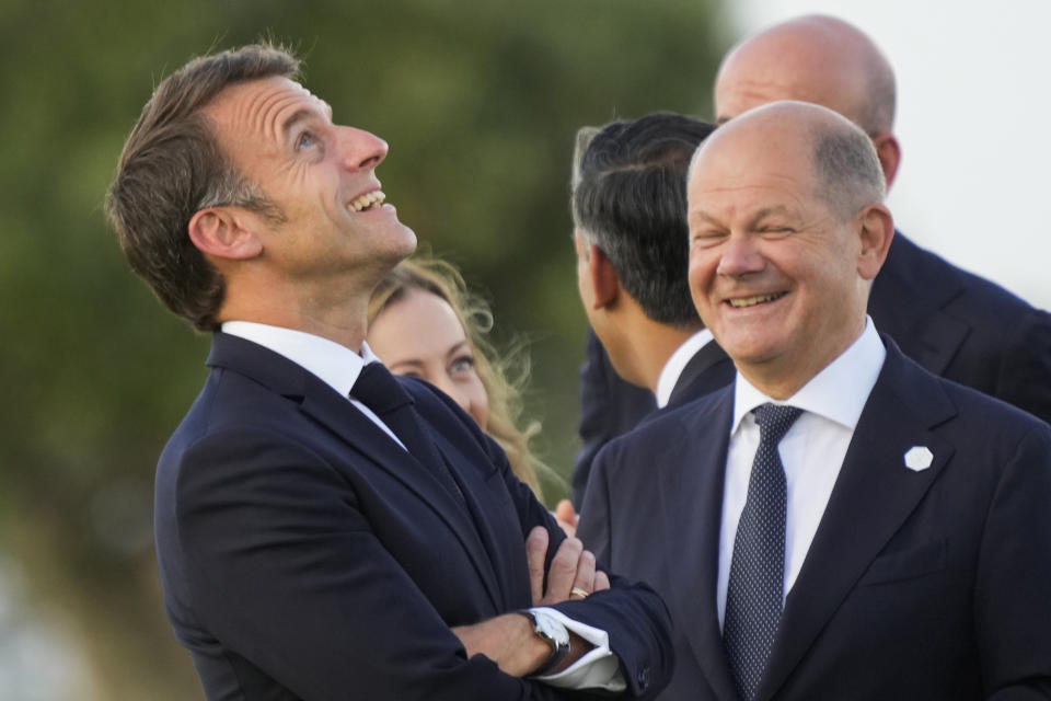 FILE - French President Emmanuel Macron, left, talks to German Chancellor Olaf Scholz as they watch a skydiving demo during the G7 world leaders summit at Borgo Egnazia, Italy, on June 13, 2024. The German government has expressed concern about a possible victory of the far-right National Rally in France. Chancellor Scholz and many ordinary Germans fears that if the the nationalist French party gets elected on Sunday, it would no longer support the close and unique relationship between the two countries that was carefully built over decades since the end of World War II. (AP Photo/Luca Bruno)