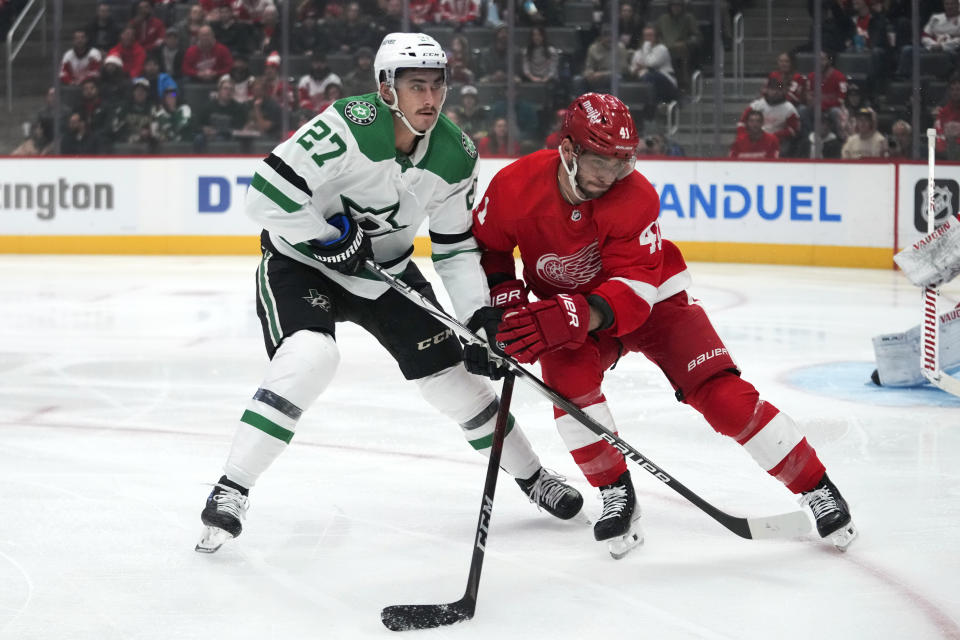 Dallas Stars left wing Mason Marchment (27) and Detroit Red Wings defenseman Shayne Gostisbehere (41) battle for position in the first period of an NHL hockey game Tuesday, Jan. 23, 2024, in Detroit. (AP Photo/Paul Sancya)