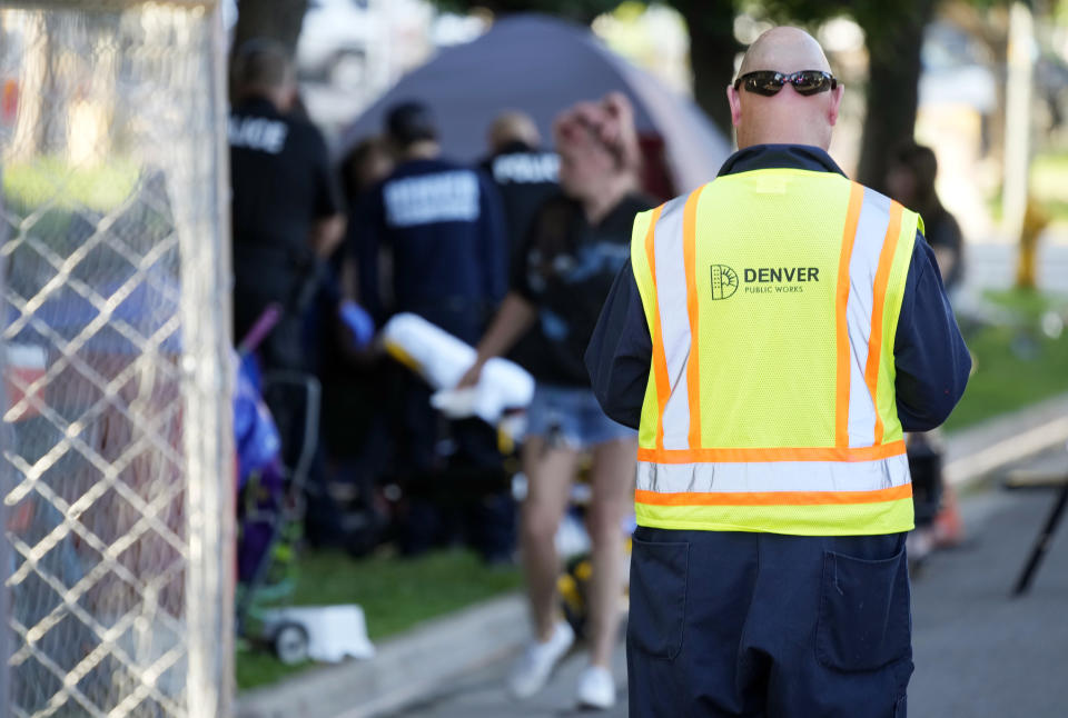 A city-sponsored sweep is carried out on an encampment of individuals living along Grant Street at Sixth Avenue south of downtown Denver, Wednesday, July 7, 2021. (AP Photo/David Zalubowski)