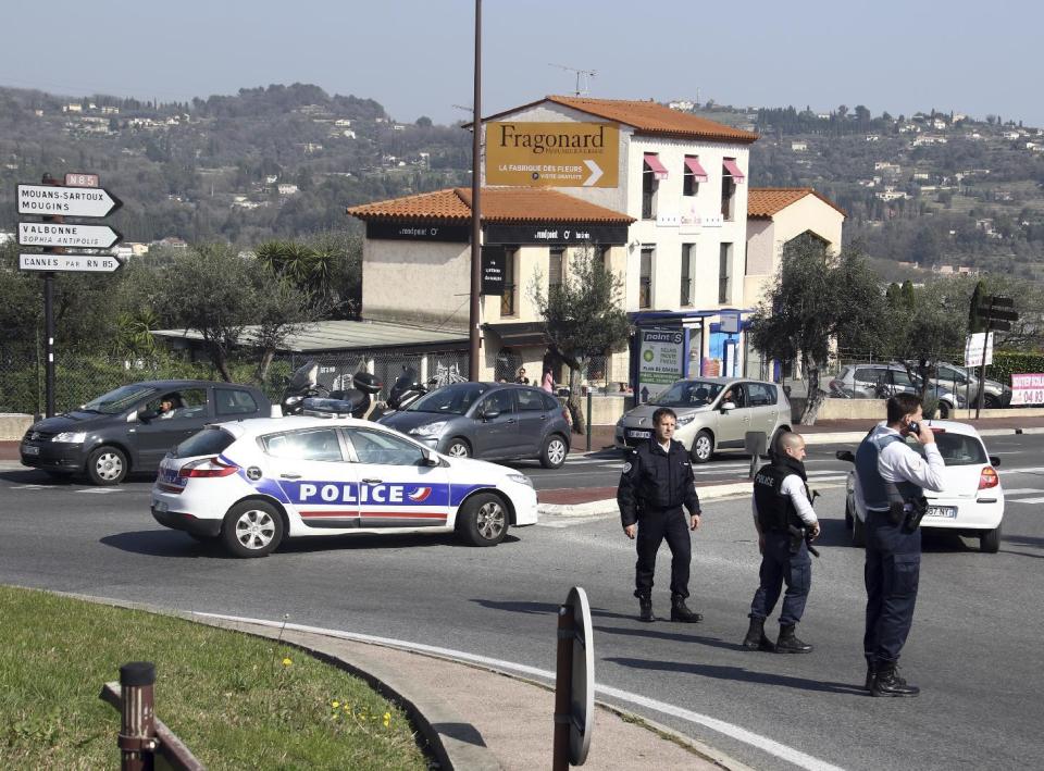 Police officers take position after an attack in a high school student in Grasse, southern France, Thursday, March 16, 2017. An armed high school student was arrested and police fanned out around a picturesque perfume capital in southern France after a school shooting that left at least two wounded. (AP Photo/Philippe Farjon)