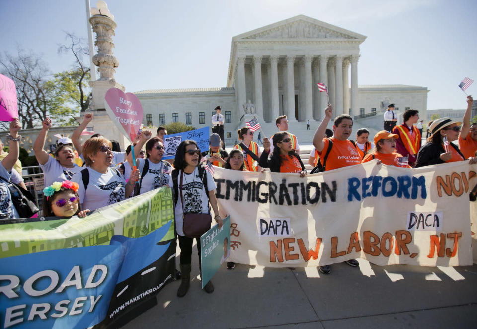 Pro-immigration supporters carry banners