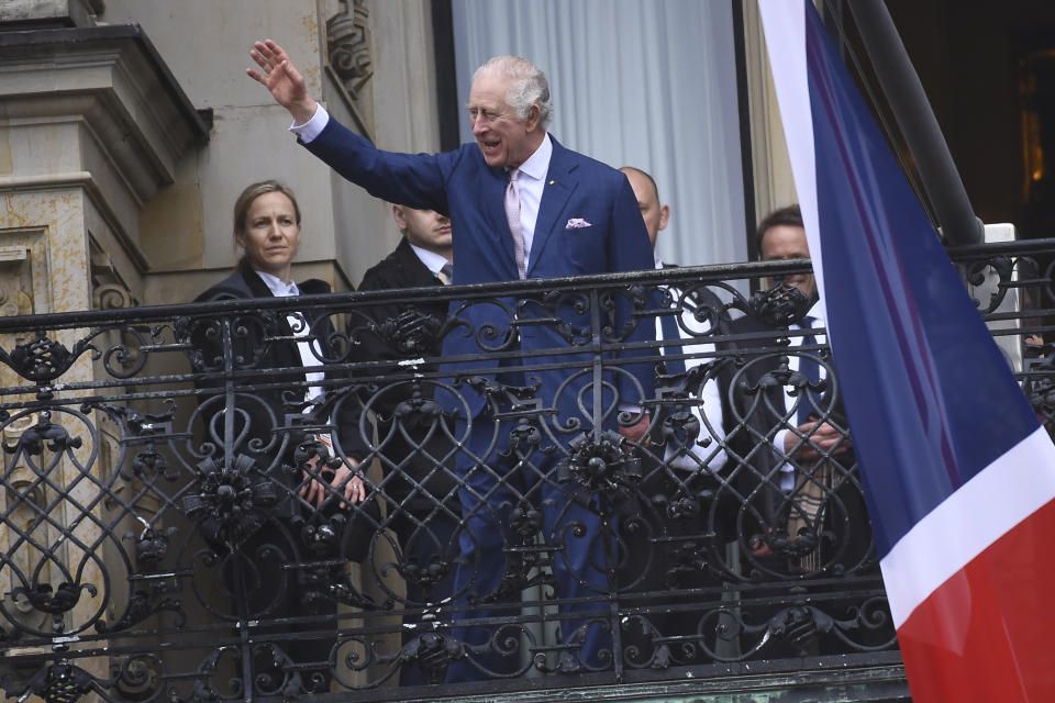 Britain's King Charles III waves from a balcony of the city hall in Hamburg, Germany, Friday, March 31, 2023. King Charles III arrived Wednesday for a three-day official visit to Germany. (AP Photo/Gregor Fischer)