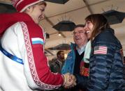International Olympic Committee (IOC) President Thomas Bach smiles as Russia's ice hockey player Iya Gavrilova (L) and U.S speed skater Anna Ringsred (R) introduce themselves during a visit in the Coastal Cluster Olympic Village in Sochi, February 4, 2014. REUTERS/Eric Gaillard