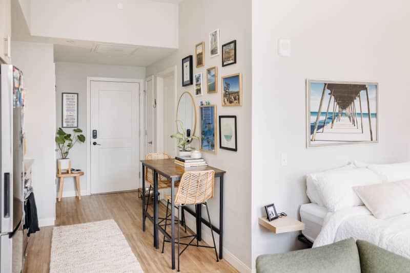 The dining area and sleeping areas of a gray studio apartment.