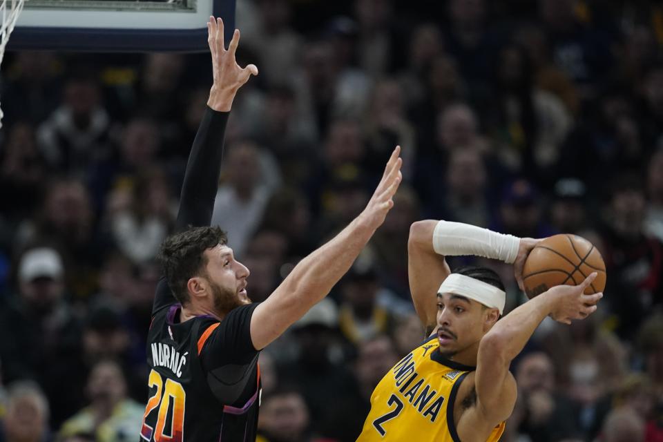 Indiana Pacers' Andrew Nembhard (2) looks to pass the ball as Phoenix Suns' Jusuf Nurkic (20) defends during the first half of an NBA basketball game Friday, Jan. 26, 2024, in Indianapolis. (AP Photo/Darron Cummings)