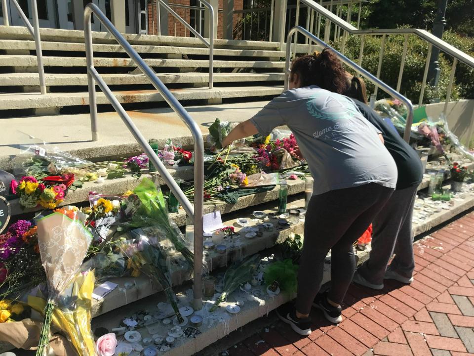 Mourners pause to look at a variety of memorials left at Kennedy Hall at UNC Charlotte on Thursday, May 2, 2019. A gunman opened fire at Kennedy on April 30, killing two and wounding four.