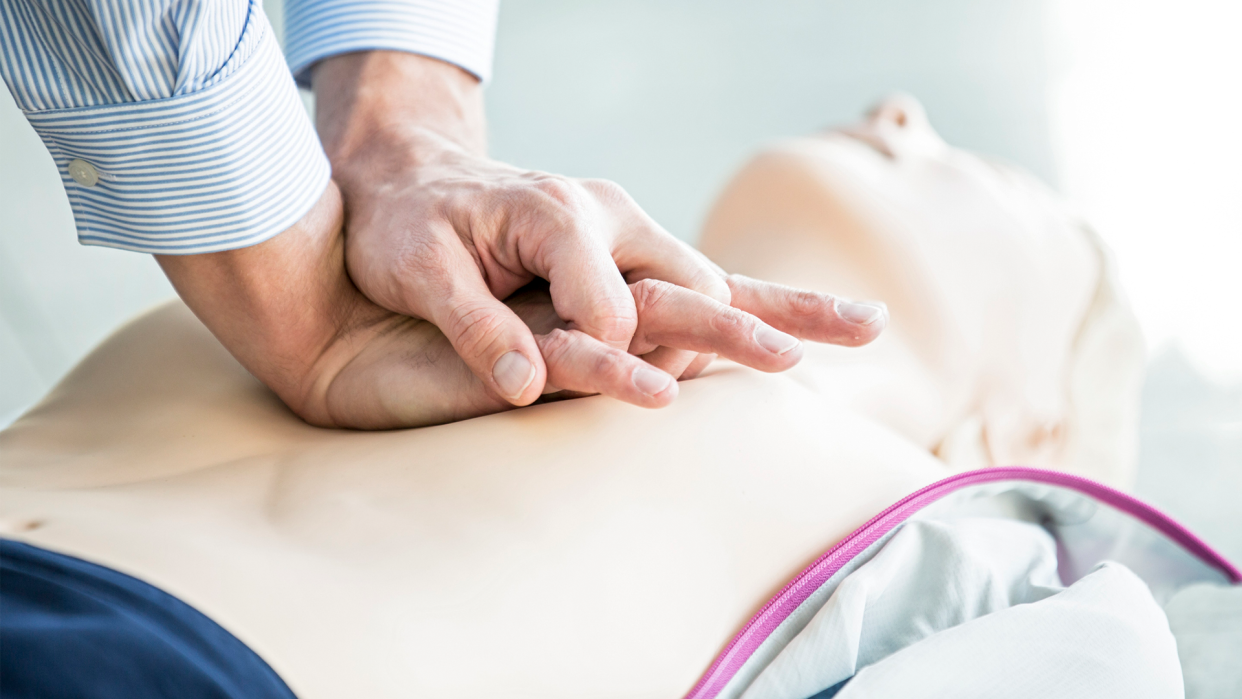 Someone performing CPR on a mannequin.