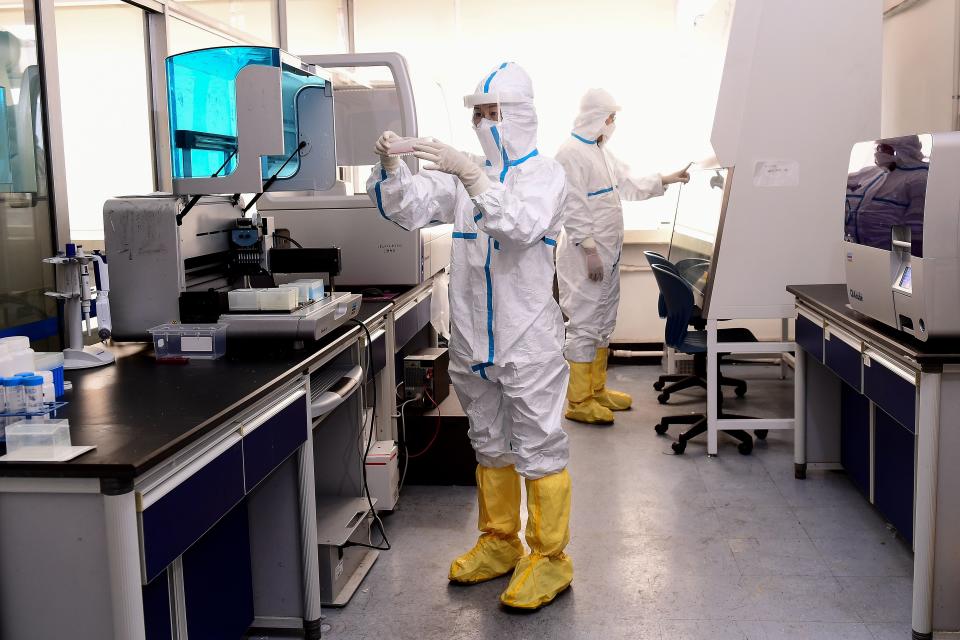 Laboratory technicians work on testing human COVID-19 samples at a laboratory in Shenyang, China, on Feb. 12, 2020.