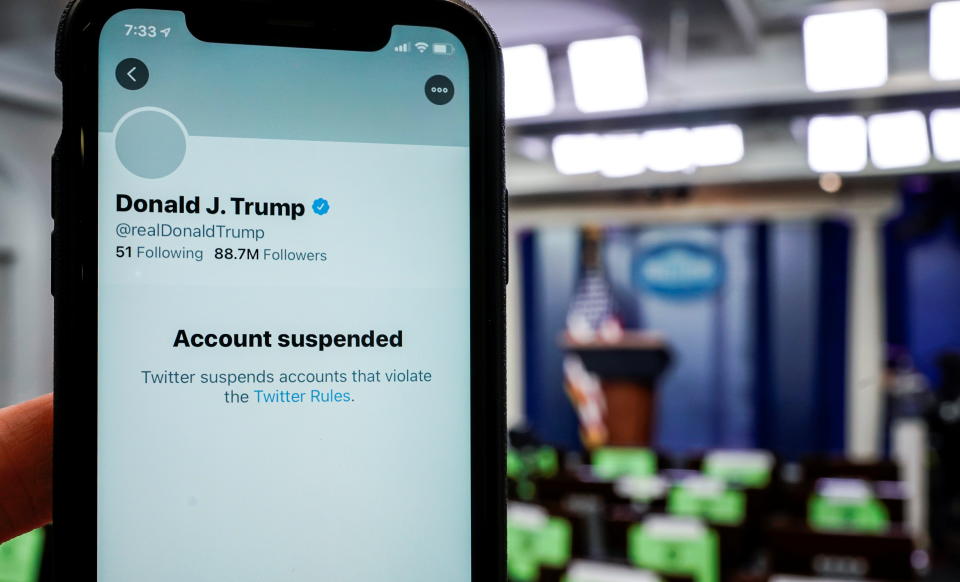 Una ilustración muestra un celular que despliega la cuenta de Twitter de Donald Trump tras ser suspendida, con la sala de prensa de la Casa Blanca de fondo. (Reuters)